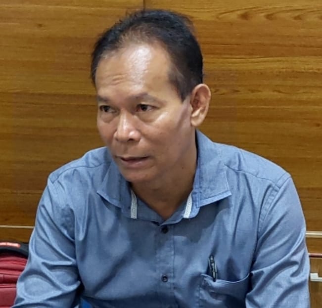 Sengkon anggota Komisi II DPRD Kalteng berbaju biru sedang berbicara di ruangan kayu, fokus pada penguatan pertanian rakyat di Palangka Raya serta dukungan bibit unggul dan fasilitas pertanian.