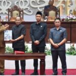 Edy Pratowo, Wakil Gubernur Kalteng, hadir bersama Agustiar Sabran dan Arton S Dohong di panggung paripurna DPRD Kalteng Palangka Raya, menandatangani LKPj 2025 dengan latar belakang dekoratif.