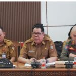Darliansjah menghadiri rapat Pansus DPRD Provinsi Kalimantan Tengah membahas Raperda Penanaman Modal dan PTSP, berseragam cokelat dan berkacamata.