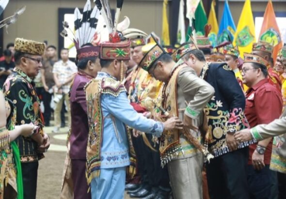 Agustiar Sabran melantik Pengurus DAD dan BATAMAD Kalteng di Aula Jayang Tingang, Palangka Raya, dalam prosesi adat Dayak yang khidmat dan berwarna-warni.