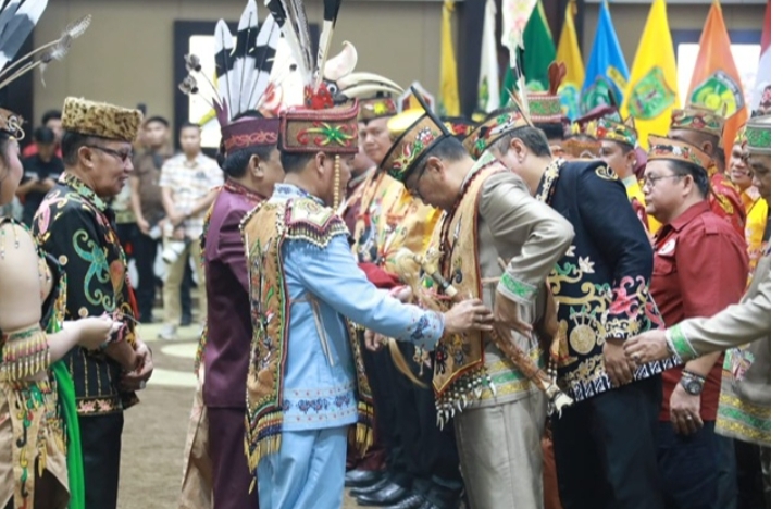 Agustiar Sabran melantik Pengurus DAD dan BATAMAD Kalteng di Aula Jayang Tingang, Palangka Raya, dalam prosesi adat Dayak yang khidmat dan berwarna-warni.