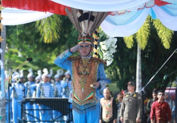 Gubernur Agustiar Sabran memimpin Upacara HUT ke-69 Kalimantan Tengah di Palangka Raya dengan busana adat biru dan hiasan kepala khas.