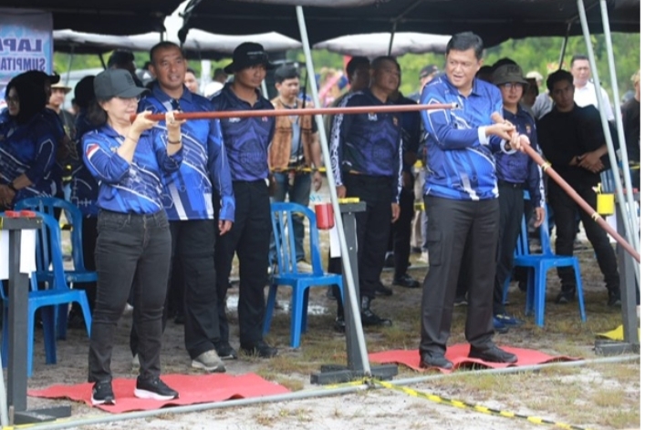 Peserta berbaju biru membidik lomba sumpit di bawah tenda, sementara pejabat dan panitia menyaksikan peringatan Hari Bhayangkara ke-80 di Palangka Raya.